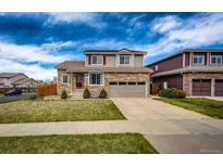 Two-story home featuring stone accents, a two-car garage, a red door, and a well-maintained front lawn at 20305 E 41St Ave, Denver, CO 80249