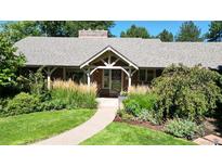 Charming brick home with a covered front entrance and lush landscaping at 2901 E Floyd Dr, Denver, CO 80210