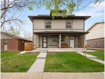 Charming two-story home with covered porch and well-manicured lawn at 3028 N Gilpin St, Denver, CO 80205