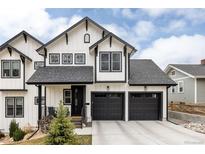 Striking two-story home featuring white siding, black trim, and a two-car garage at 2020 Teller St, Lakewood, CO 80214