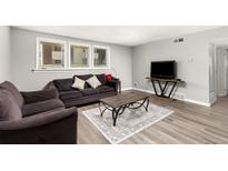 Bright living room with comfy sofas, a coffee table, and wood-look flooring at 10211 Ura Ln # 7-108, Thornton, CO 80260