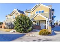 Tan and green two-story townhome with a small front yard and walkway at 11844 Oak Hill Way # A, Commerce City, CO 80640