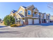 Townhome exterior featuring well-maintained landscaping and attached garages at 11844 Oak Hill Way # A, Commerce City, CO 80640