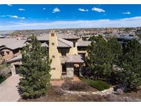 Stunning Mediterranean home with a red tile roof and lush, mature landscaping at 8002 Galileo Way, Littleton, CO 80125