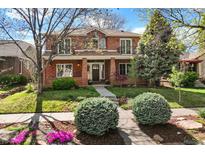 Stately brick two-story home featuring manicured front yard and charming architectural details at 1215 S Ogden St, Denver, CO 80210