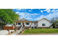 Charming home featuring a covered porch, manicured lawn, and stone accents at 5372 W 68Th Ave, Arvada, CO 80003
