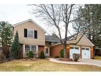 Charming two-story home with a brick facade, attached two car garage, and beautifully landscaped front yard at 7743 S Jersey Way, Centennial, CO 80112