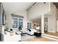 Bright living room with high ceilings, fireplace, and large windows providing ample natural light at 7743 S Jersey Way, Centennial, CO 80112