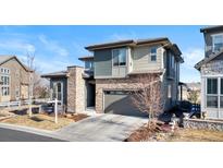 Beautiful two-story home with a stone and siding exterior, attached garage, and manicured front yard at 507 Red Thistle Dr, Highlands Ranch, CO 80126