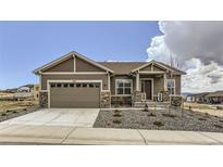 Craftsman style home featuring a two-car garage, stone accents, a covered porch, and professional landscaping at 483 Agoseris Way, Castle Rock, CO 80104