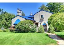 Charming home featuring a blue tile roof, stucco walls, and lush landscaping at 6 Ivy Ln, Denver, CO 80220