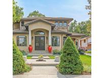 Elegant home featuring a symmetrical design, red urns, and a well-manicured lawn with trimmed bushes at 6246 W 35Th Ave, Wheat Ridge, CO 80033