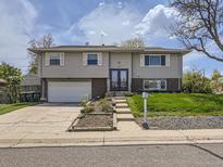 Charming two-story home featuring a well-maintained front yard, garage and inviting entrance at 1488 W 102Nd Ave, Northglenn, CO 80260
