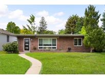 Charming single-story brick home with a well-manicured lawn and walkway to the front door at 1035 S Garfield St, Denver, CO 80209