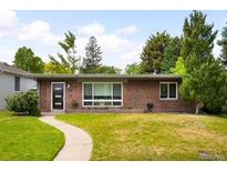 Charming red brick ranch-style home with a well-manicured lawn and mature trees creating curb appeal at 1035 S Garfield St, Denver, CO 80209
