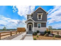 Charming two-story home featuring a modern design with gray siding and a welcoming front porch at 2121 Barnwood Dr, Brighton, CO 80601