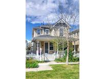 Charming two-story home featuring a classic white picket fence and lovely front yard landscaping at 2846 Central Park Blvd, Denver, CO 80238