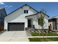 Charming two-story home with white siding, a gray garage door and a well-manicured lawn at 1121 Joseph Pl, Erie, CO 80026
