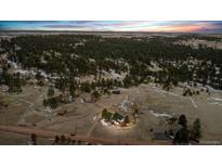Expansive aerial view of a secluded home surrounded by natural landscape and trees at 11840 Elkhorn Dr, Franktown, CO 80116