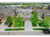 Stunning two-story home showcasing lush landscaping, mature trees, and an expansive driveway at 4738 Colorado River Dr, Firestone, CO 80504