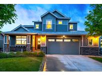 Charming two-story home with a two-car garage and well-maintained front yard and stone facade at 4738 Colorado River Dr, Firestone, CO 80504