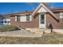 Charming brick home featuring a covered front door and manicured rock garden at 12771 W 6Th Pl, Lakewood, CO 80401