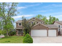 Traditional two-story home featuring a three-car garage, brick accents, and a well-maintained lawn at 20740 Parker Vista Rd, Parker, CO 80138
