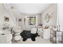 Bright living room features a modern design with a plush sofa, statement rug, and ample natural light from a large window at 20740 Parker Vista Rd, Parker, CO 80138