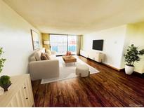 Bright living room featuring a sliding door to a balcony, hardwood floors, and comfortable seating arrangements at 1155 N Ash St # 908, Denver, CO 80220