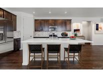 Bright eat-in kitchen with stainless steel appliances, island with chairs, and modern fixtures at 39743 Penn Rd, Elizabeth, CO 80107