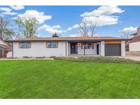 Charming single-story home with a well-manicured lawn, and a one car garage at 8622 W Warren Ln, Lakewood, CO 80227