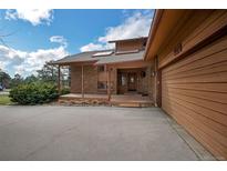 Charming single-Gathering home featuring a brick facade, covered porch, and an attached two-car garage at 6275 Lakewood Rd, Parker, CO 80134