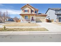 Charming two-story home featuring a welcoming front porch and a well-maintained lawn at 9821 Mobile St, Commerce City, CO 80022