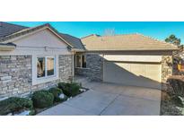 Stone exterior with two-car garage and landscaping at 14032 E Chenango Dr, Aurora, CO 80015