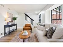 Bright living room featuring a comfortable white sofa, stylish furniture, and natural light from the window at 10310 E Jewell Ave # 57, Aurora, CO 80247