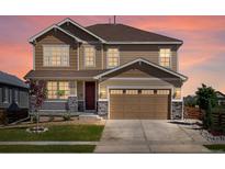 Charming two-story home featuring a two-car garage, covered porch, and beautifully landscaped front yard at 800 Boulder Peak Ave, Erie, CO 80516