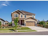 Charming two-story home with a two-car garage, lush lawn, and inviting front porch at 800 Boulder Peak Ave, Erie, CO 80516