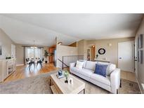 Inviting living room and dining area featuring sleek furniture, light colored walls, and lots of light at 11813 Bellaire Cir, Thornton, CO 80233