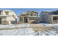 Two-story house with gray siding, stone accents, and a two-car garage at 238 Kino Court, Brighton, CO 80601