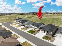An exterior street-view of modern, suburban homes with a scenic view and arrow graphic at 5707 Cadara Way, Parker, CO 80134