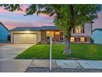 Charming home boasts a well-manicured lawn, two-car garage, and inviting exterior at 18601 E Louisiana Ave, Aurora, CO 80017