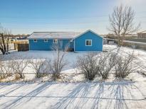 Ranch style home with fenced yard, winter scene at 329 Lilac Dr, Lochbuie, CO 80603