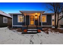 Inviting home exterior with a covered front porch, ironwork, and fresh landscaping at 4855 Knox Ct, Denver, CO 80221