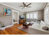 Cozy living room featuring hardwood floors, a ceiling fan, and a comfortable sectional sofa at 4855 Knox Ct, Denver, CO 80221