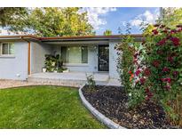 Charming home featuring a welcoming front entrance, blooming roses and a well-maintained lawn at 7650 W 24Th Ave, Lakewood, CO 80214