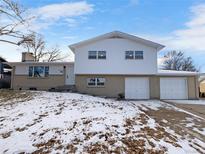 Ranch style home with attached two-car garage and snowy front yard at 10547 Pompey Way, Northglenn, CO 80234