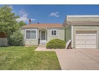 Charming single-story home with light green siding, well-kept lawn, and a detached single car garage at 16149 E Rice Pl # A, Aurora, CO 80015
