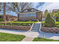 Beautiful brick home with a landscaped front yard, stone retaining wall, and concrete steps to the entrance at 1230 S Emerson St Dr, Denver, CO 80210