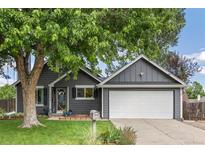 Charming gray single Gathering home featuring a two-car garage and beautifully manicured lawn at 18056 E Bellewood Dr, Aurora, CO 80015