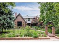 Brick home with landscaped yard and black fence at 4500 Montview Blvd, Denver, CO 80207